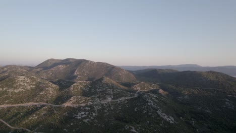 drone-video-over-the-Opuzen-area-in-Croatia,-recording-the-mountain-range-at-sunset-on-highway-8,-car-traffic-can-be-seen-in-the-distance