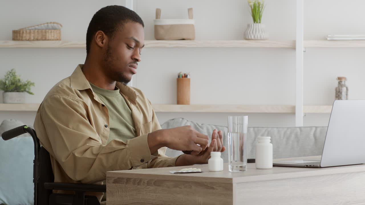 Man in Wheelchair Taking Medication