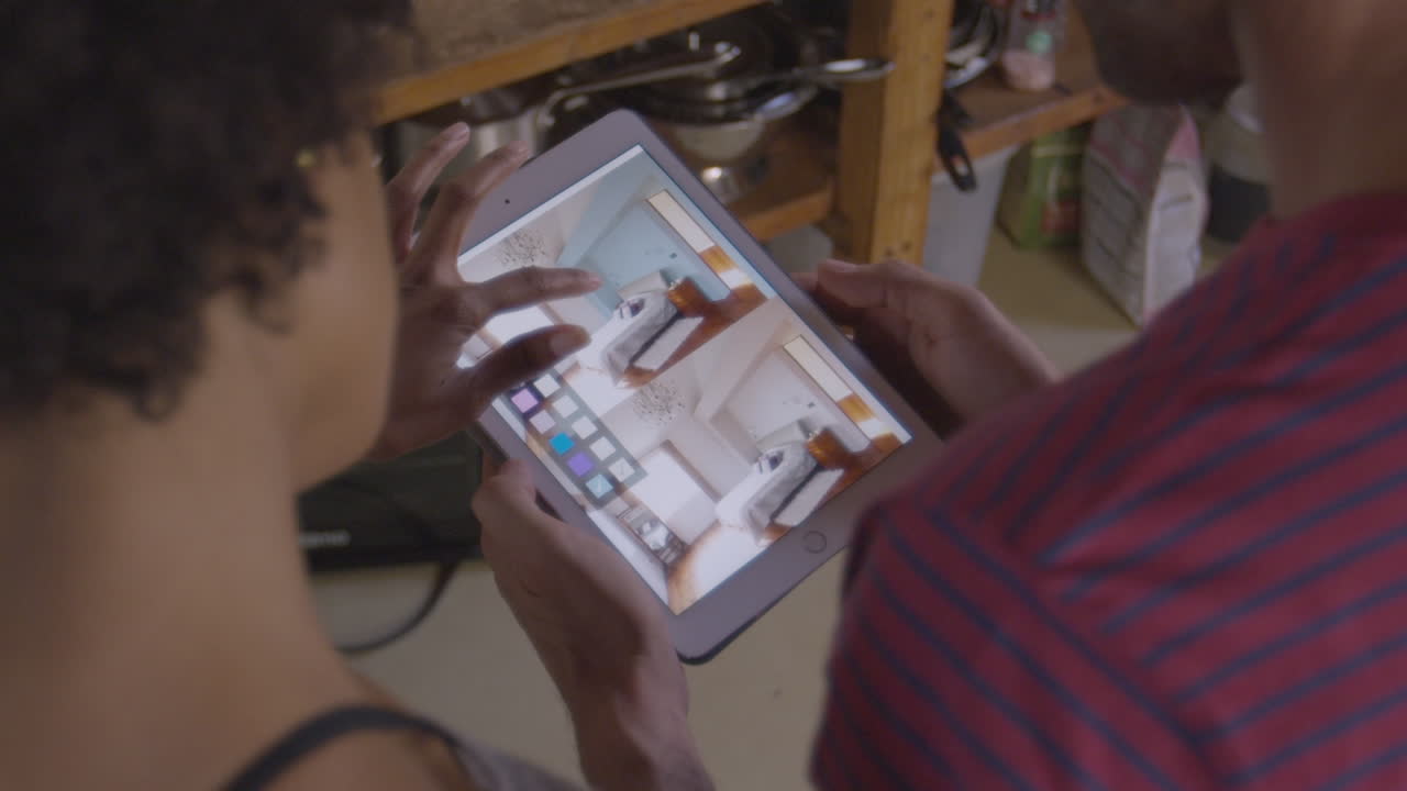 Young couple using tablet computer, over shoulder view, shot on R3D