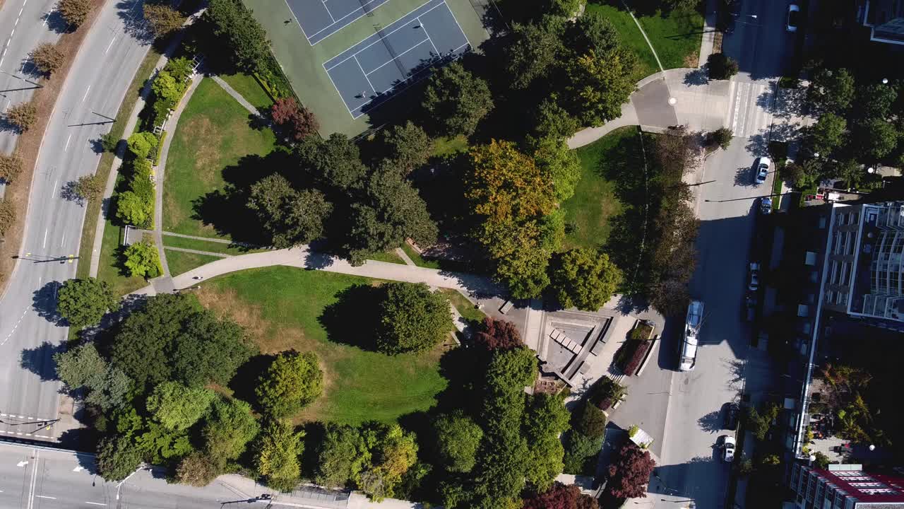 control aéreo sobre un exuberante parque urbano moderno y circular dentro de una comunidad residencial de lujo en el centro de la ciudad junto a un servicio de autobús de transporte público ecológico conectado a líneas eléctricas de trolebuses por la autopista 2-3