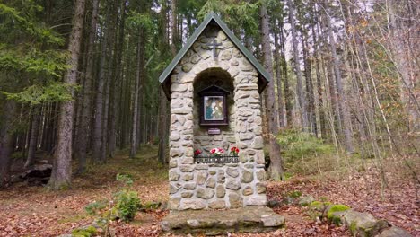 Memorial-monument-in-the-woods,-visiting-tourist-place-during-snowfall-in-early-spring,-Czech-Republic