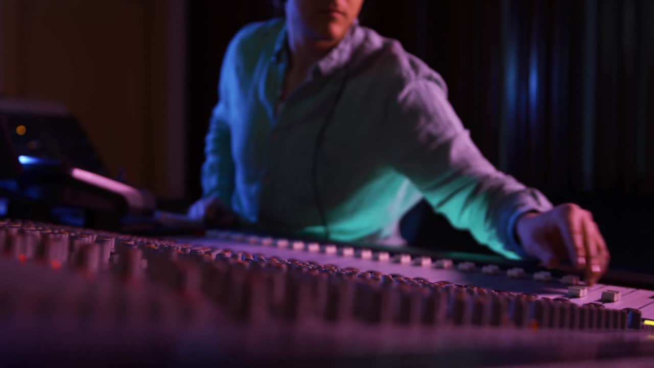 ingeniero de sonido masculino trabajando en una mesa de mezcla