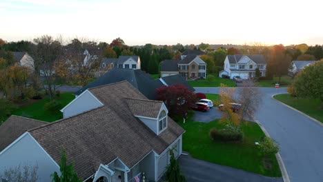 usa flag on a quaint home in american neighborhood during autumn sunset