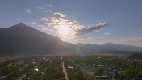 Antena-De-Crested-Butte-Con-Sol-Saliendo-Sobre-La-Montaña-Panorámica-Sobre-La-Ciudad-Montañosa-De-Colorado