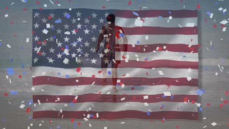 Animation-of-american-flag-and-confetti-over-african-american-man-with-surfboard-at-beach