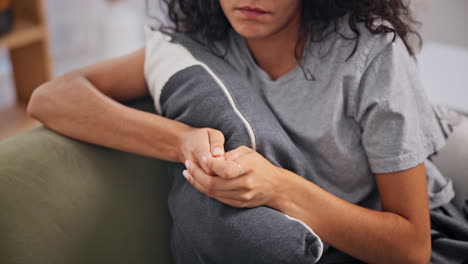 woman sitting on sofa, showing signs of sadness or anxiety