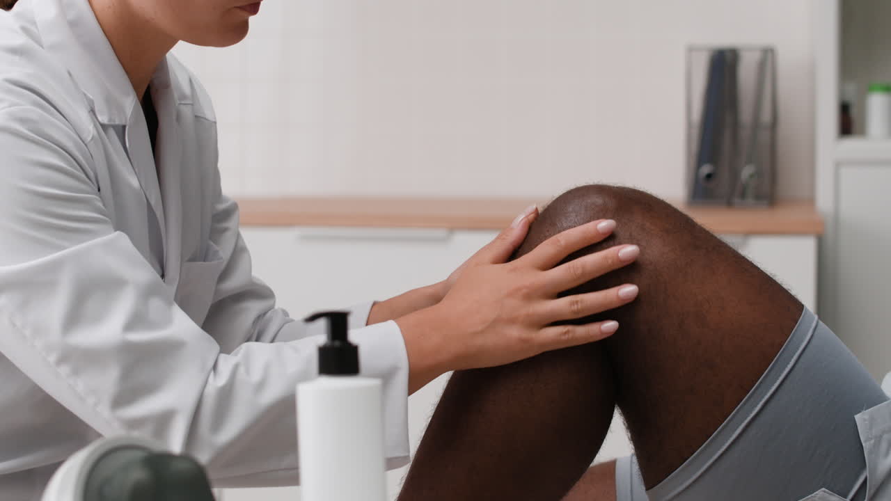 Physical therapist massaging patient's knee