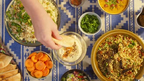 eating bulgur with eggplant and hummus top view. falafel, bean soup, couscous with chicken. traditional middle eastern culture. moutabal and vegetable salad in bowls. delicious rice with meat