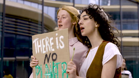 mujeres sosteniendo que no hay tablero del planeta b y flor de margarita en una protesta 1