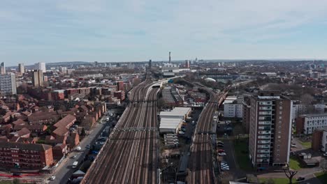 drone shot over train tracks leaving london in southwark