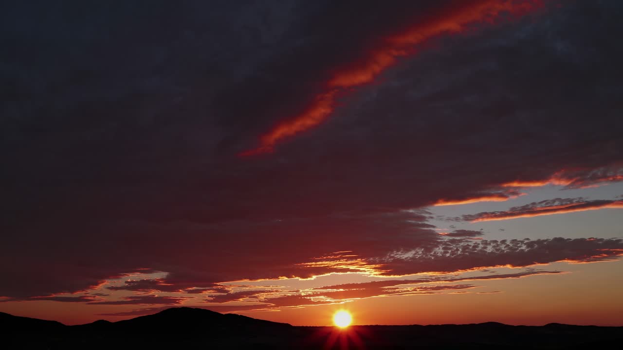 En betagende solnedgangsvideo fanger horisonten i øjenhøjde, med levende røde og orange nuancer, der maler himlen.