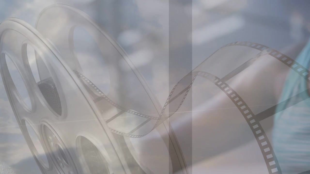 Makaranın üzerine bindirilmiş film şeridiyle, oynatmak için filmi ayarlamak üzere makarayı manipüle eden kadın.