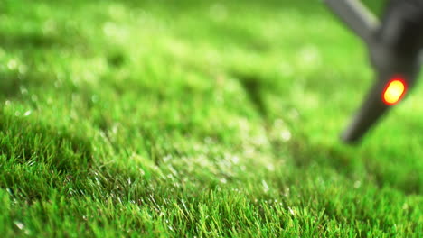 Drone With A Camera Mounted Ending Its Flight On Sunlit Green Grass - Close Up and Slow Motion