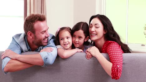 Smiling-family-posing-on-sofa-