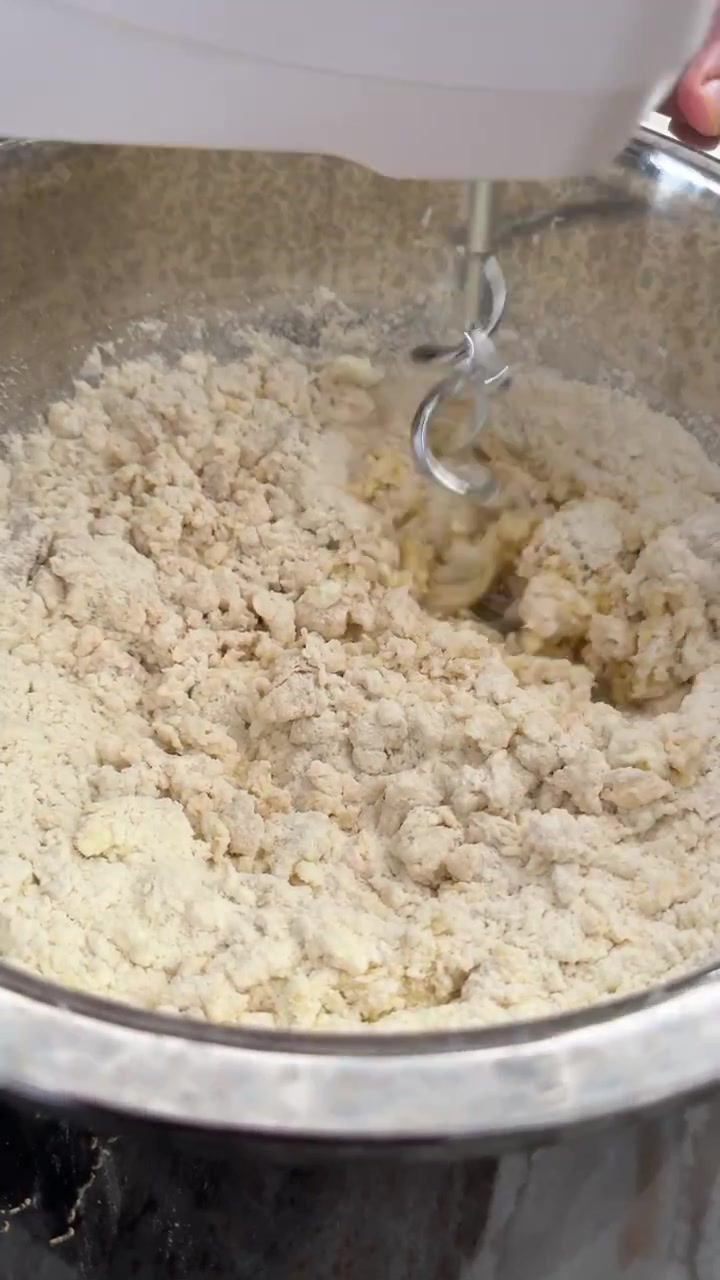 Sbattitore elettrico che amalgama farina e ingredienti in una ciotola di metallo