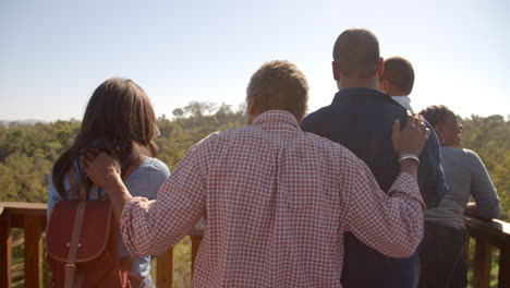 Familia-Multigeneracional-Admirando-La-Vista-Desde-La-Cubierta,-Vista-Posterior