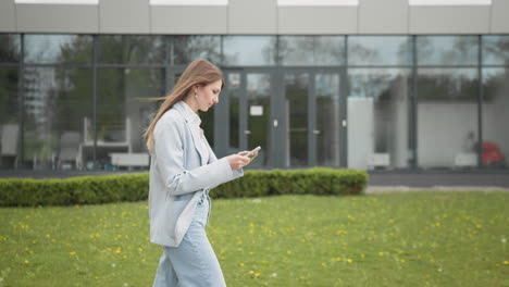 happy young woman receiving discount for shopping while checking email box while walking in urban