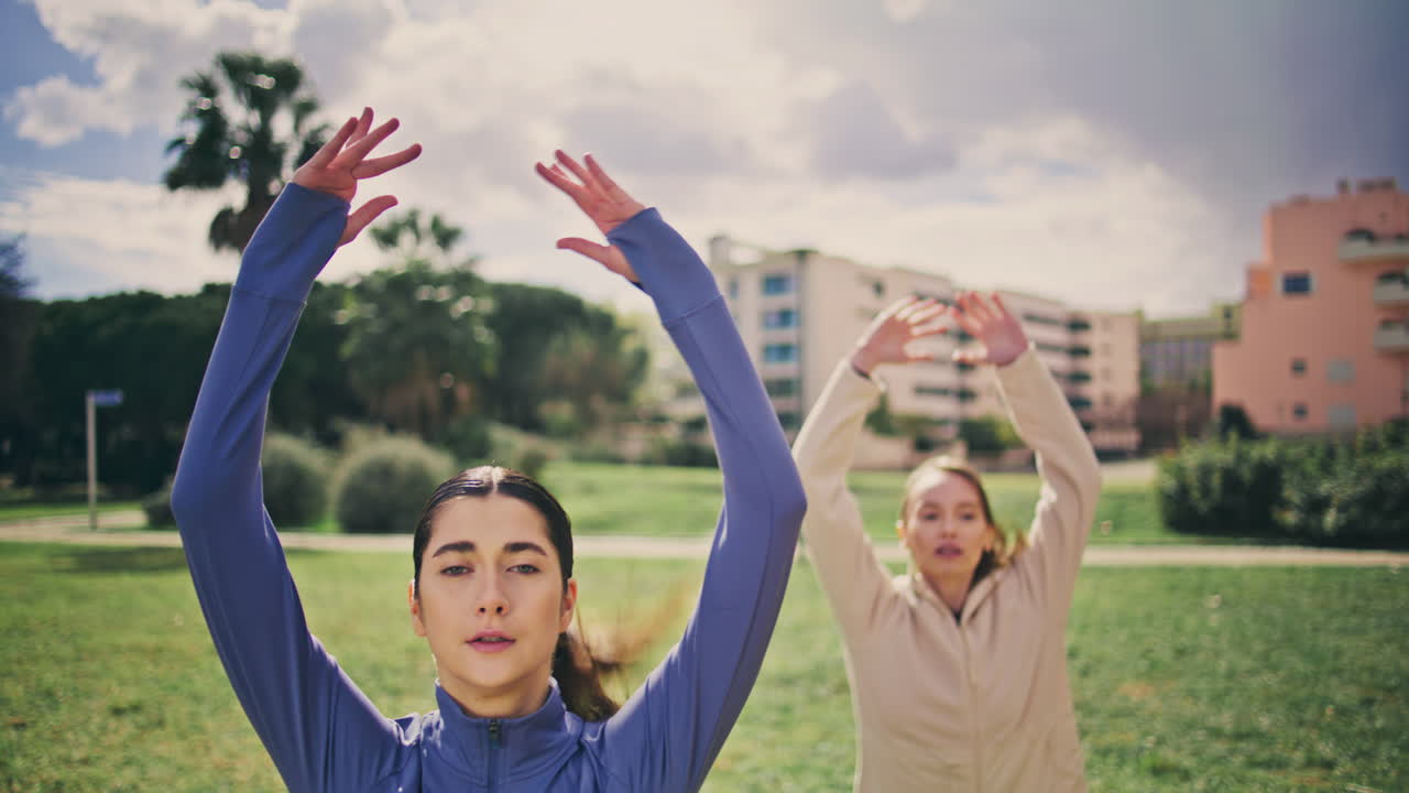 Sport besties jumping park cloudy nature closeup. Active ladies cardio workout