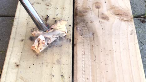Macro-view-of-making-fire-on-paper-using-friction-on-wooden-plank