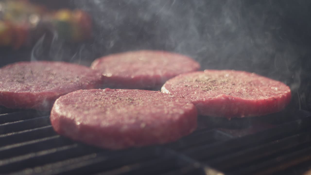 fotografía de cerca de las hamburguesas perfectas chisporroteando en la parrilla en un día de verano