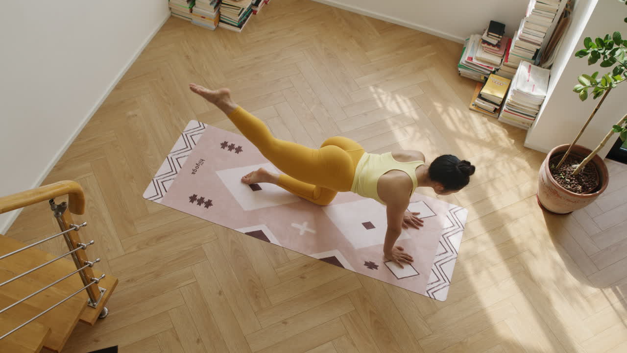 vista de arriba hacia abajo de las piernas de una mujer asiática ejercicios de estiramiento muscular en un apartamento moderno habitación, yoga práctica diaria de fitness joven asiática en ropa deportiva amarilla