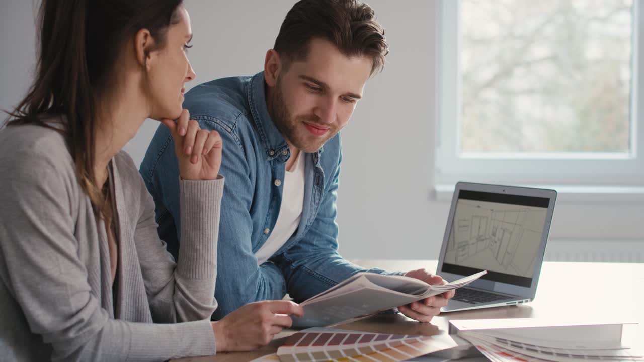 pareja caucásica eligiendo el proyecto de una nueva cocina