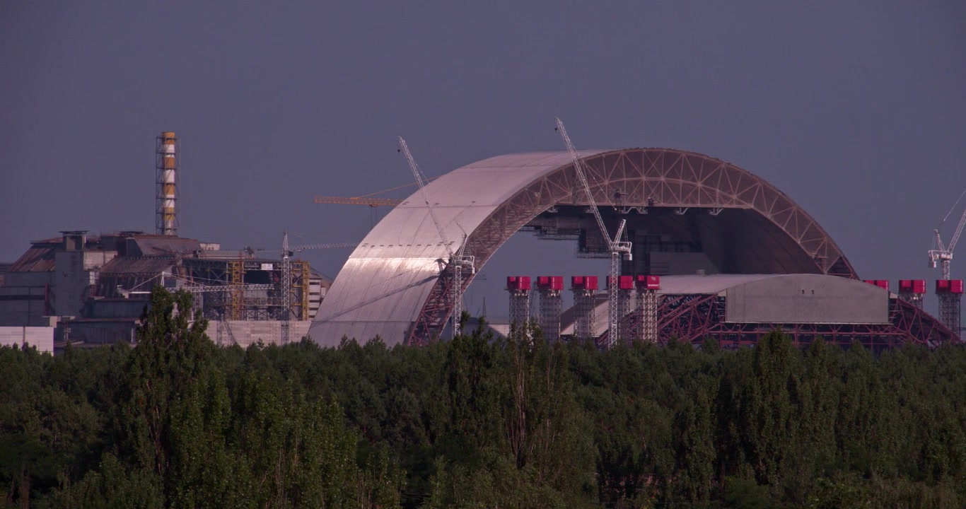 A camera pans across the Chernobyl power plant and confinement arch site.