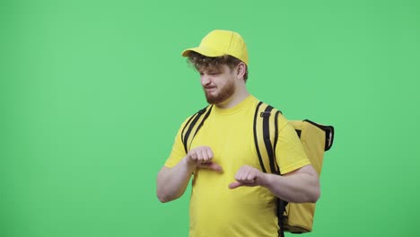 retrato de hombres jóvenes que muestran los pulgares hacia abajo gesto. hombre pelirrojo en uniforme de mensajero de entrega amarillo con bolsa térmica posando en pantalla verde en el estudio. primer plano. cámara lenta lista 59.97fps