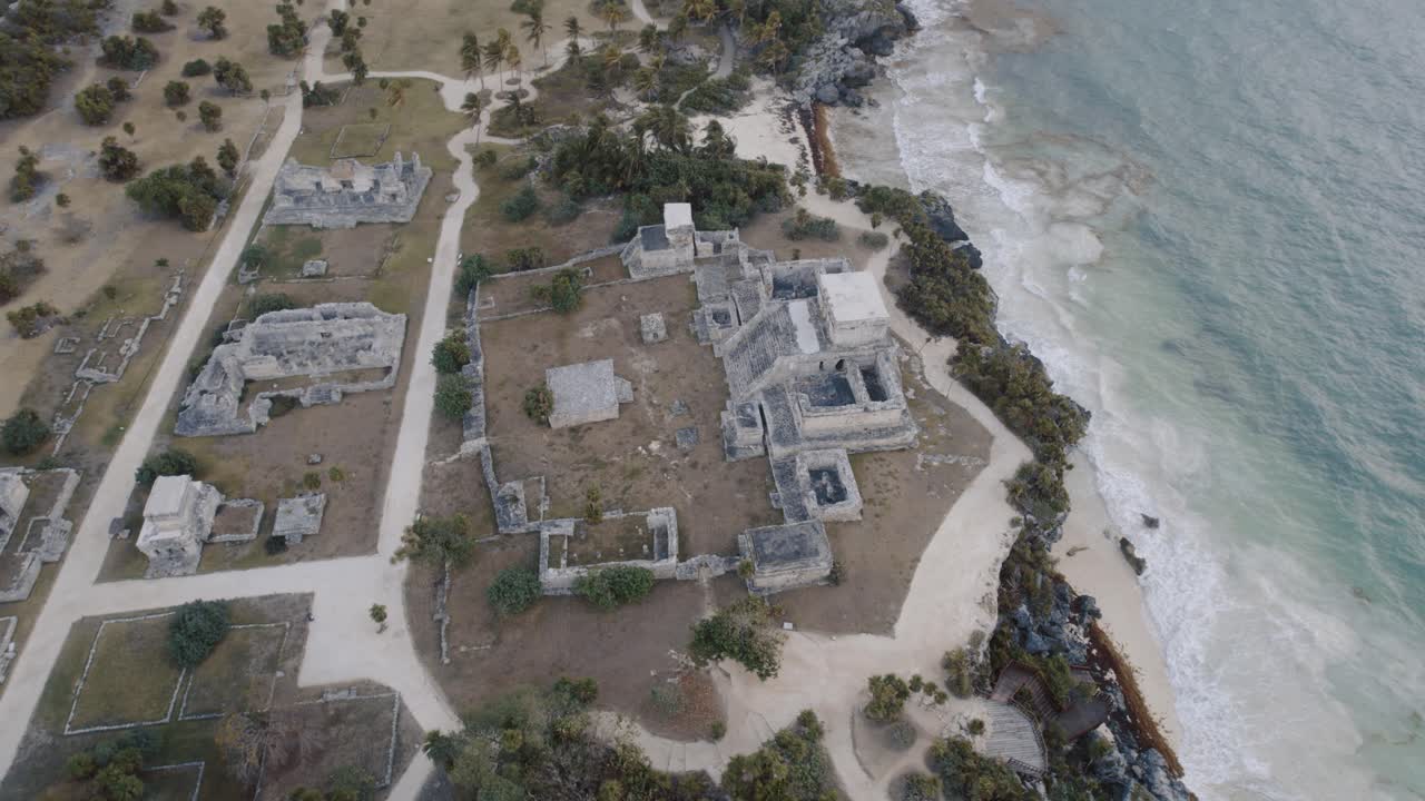 toma aérea de drones giratorios de las ruinas mayas en la playa de tulum con una vista maravillosa del mar y el paisaje con árboles y rocas en 4k