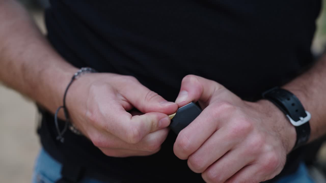 persona carga balas de combate de 9mm en el cargador de la pistola, campo de tiro de olesko