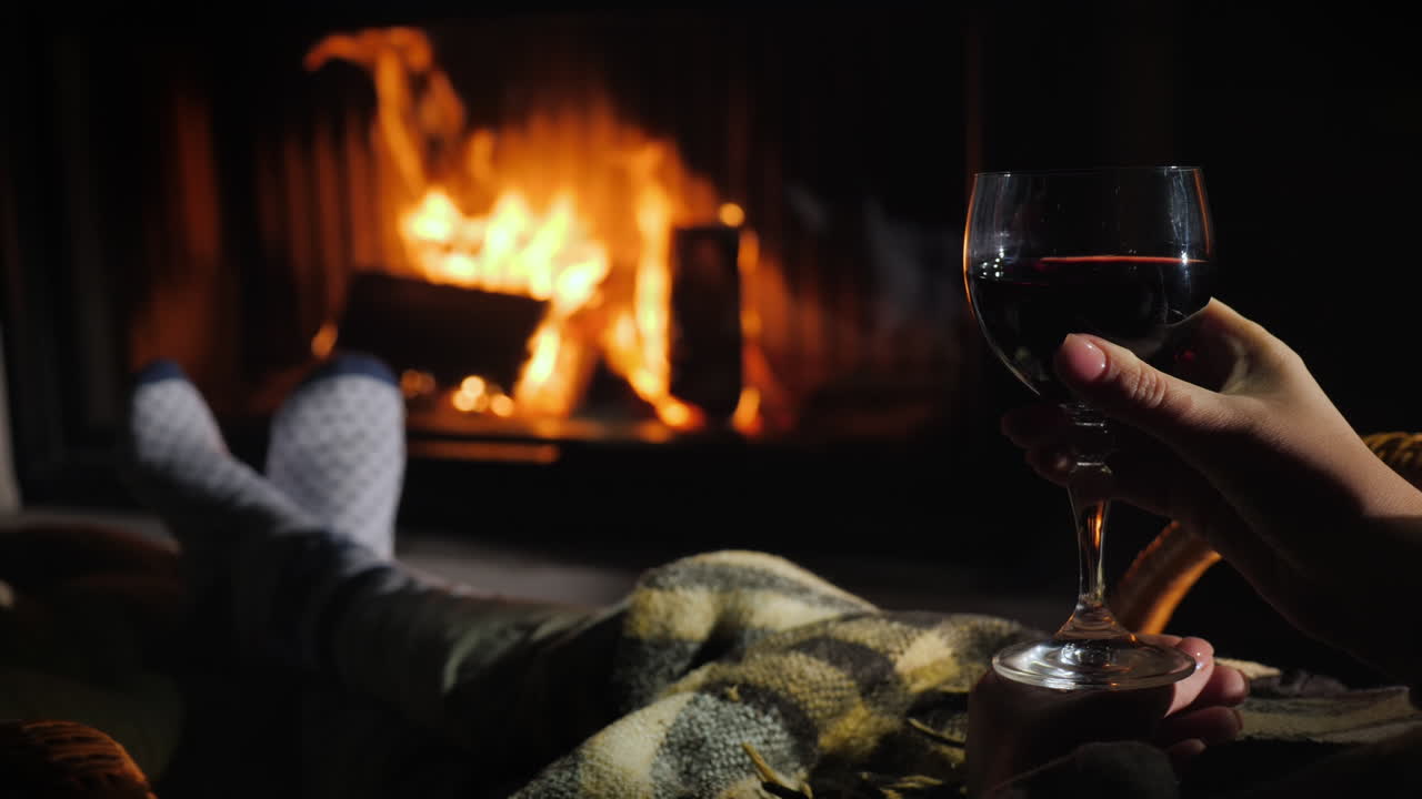 disfrutar bajo una manta junto a la chimenea con una copa de vino en la mano concepto de escape de invierno