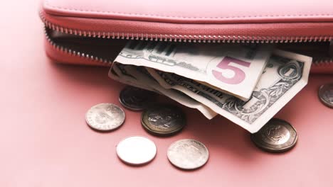 pink wallet with money and coins