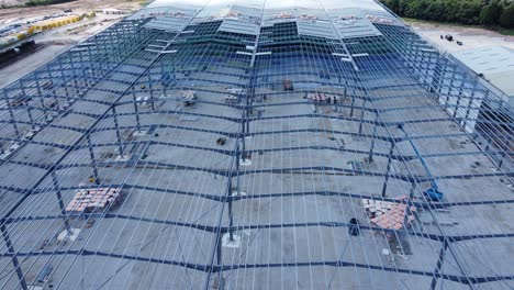 la industria de la construcción de vigas de hierro metálico marco de almacén sitio de construcción vista aérea cerrar dolly hacia adelante a la izquierda