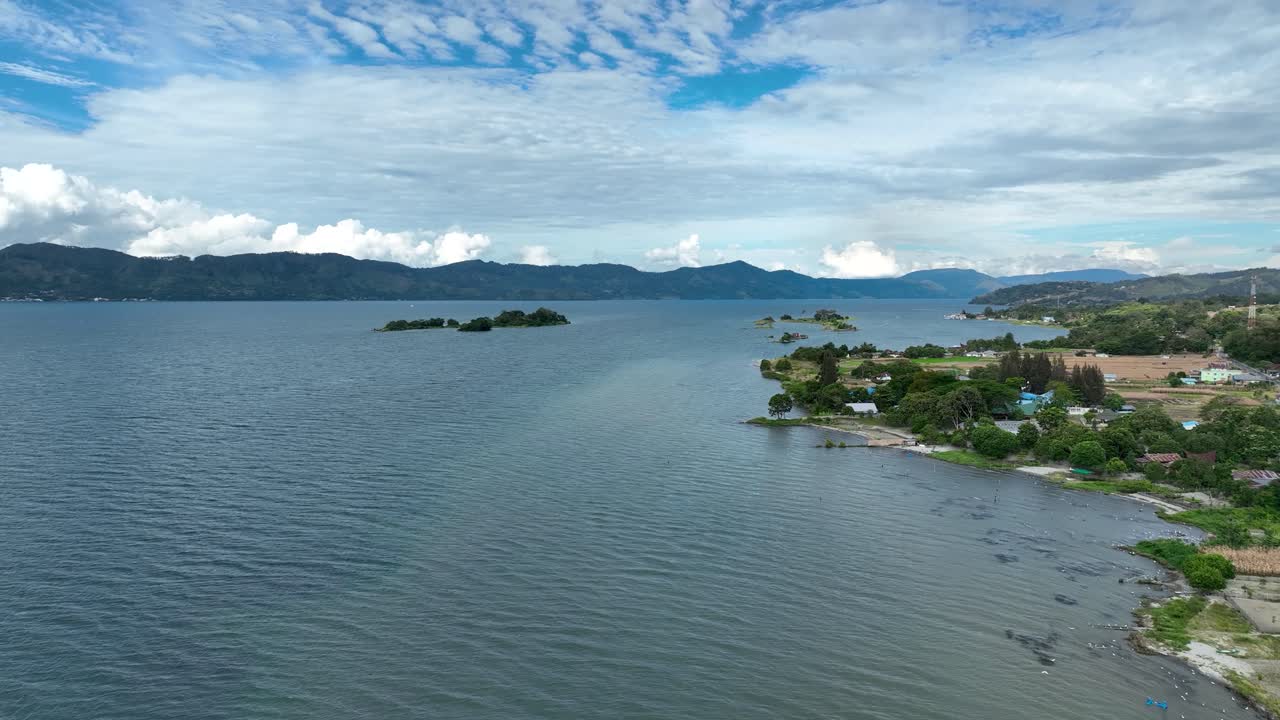 las claras aguas azules del lago toba golpean suavemente contra la costa.