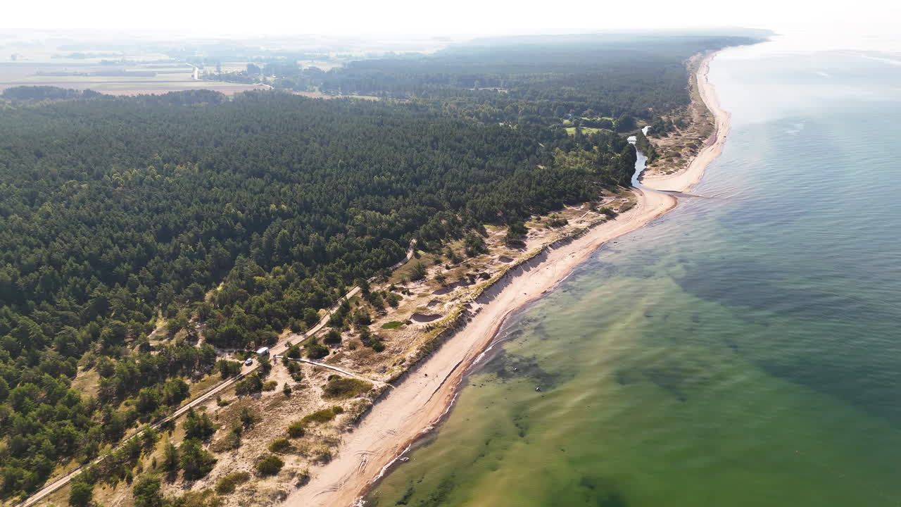 Spectacular Drone Shot Revealing A Long Stretch Of Sandy Coastline In Uzava, Latvia. A Place Where The Uzava River Meets The Baltic Sea.