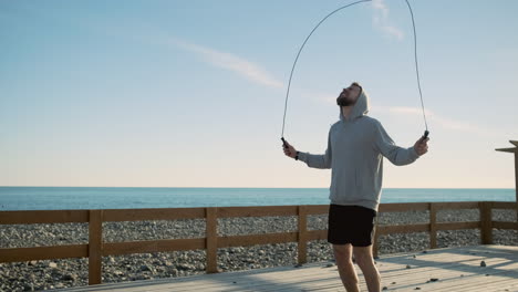 hombre saltando la cuerda en la playa