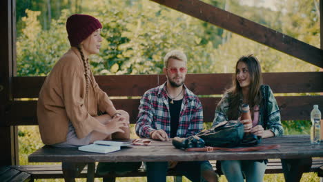 woman wearing knit hat talking to tourists sitting on bench