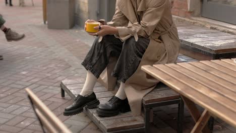 La-Mujer-De-Moda-Está-Sentada-En-Las-Escaleras-De-Madera-Afuera-Y-Tomando-Café