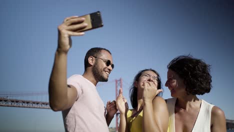 happy multiethnic friends taking selfie