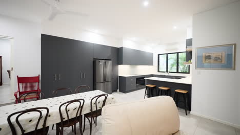 modern lived in home loungeroom with beige leather lounge chairs and dark grey black cabinet and chairs