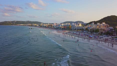 toma estática aérea volando sobre el mar en la playa de bombas, brasil a la hora dorada