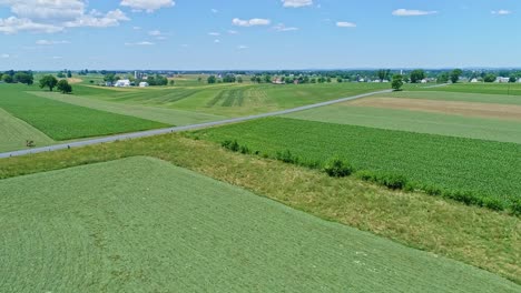 Eine-Luftaufnahme-Der-Farmlandschaft-Mit-Bepflanzten-Feldern-Und-Weiden-An-Einem-Schönen-Sonnigen-Tag