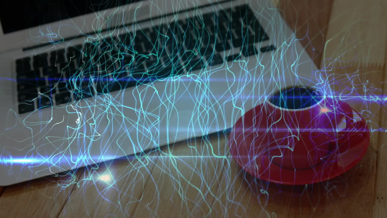 Tech workspace being animated with silver laptop keyboard, red coffee cup and data light trails