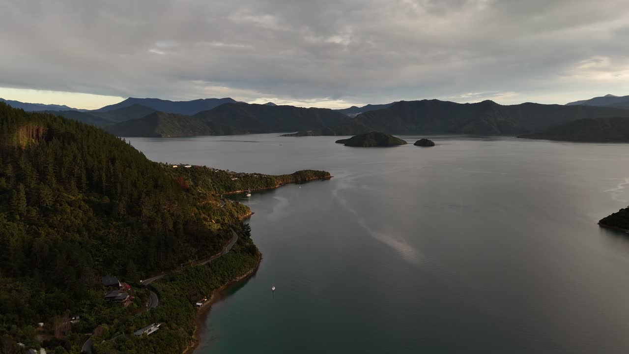 Breathtaking 4K drone footage captures the golden hour sunset over Cook Strait in the Picton area of New Zealand's South Island, creating a serene and majestic scene