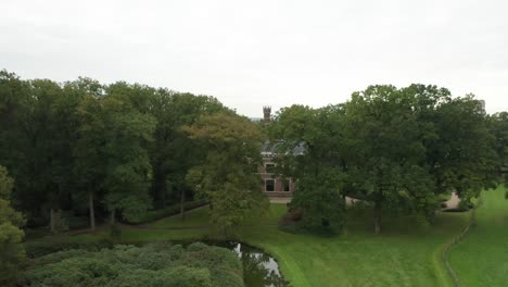 jib up of beautiful green estate with a monumental mansion in the background