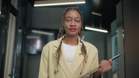 positive-black-woman-with-trendy-hairstyle-works-in-office-portrait-in-contemporary-interior