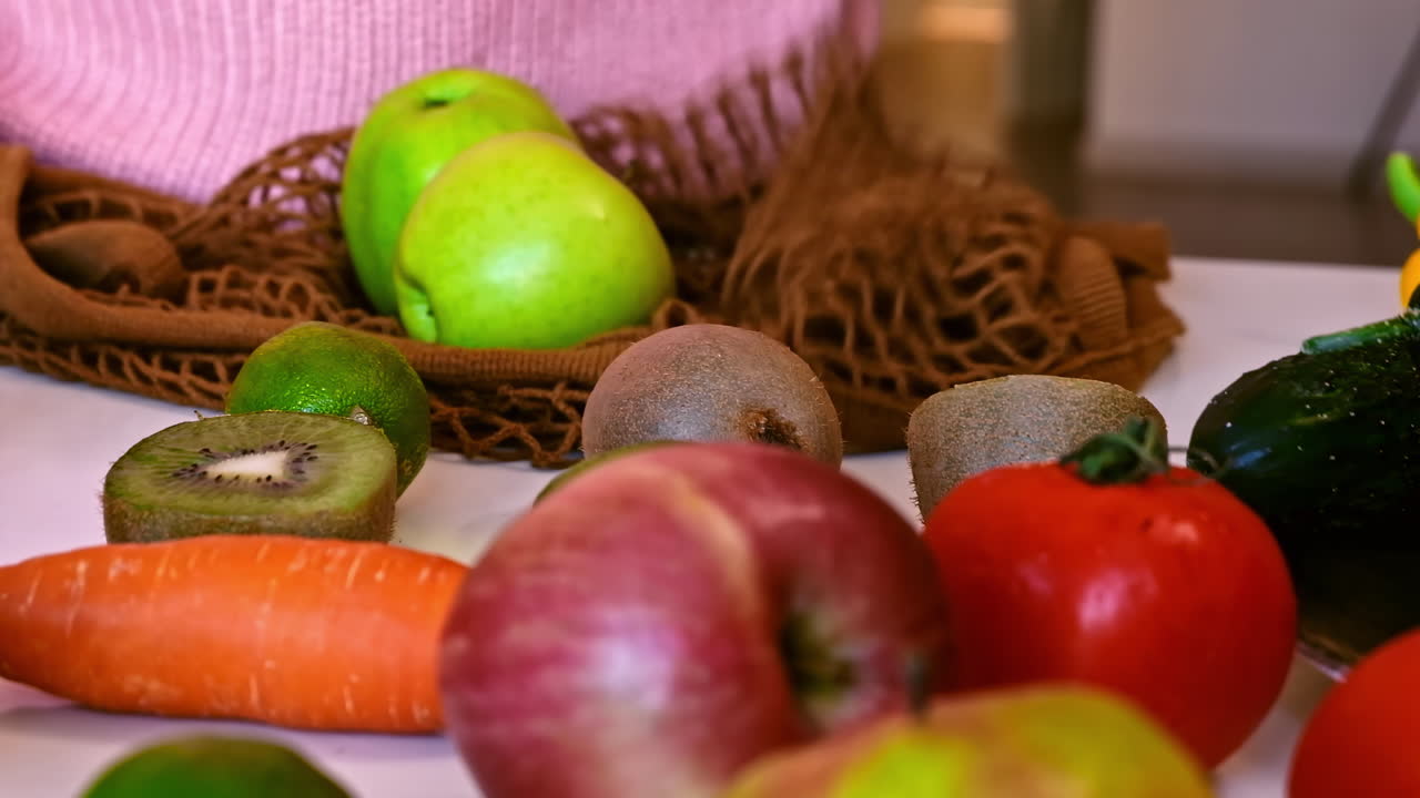 Woman hands puts a grocery bag with apples on a table and takes them out