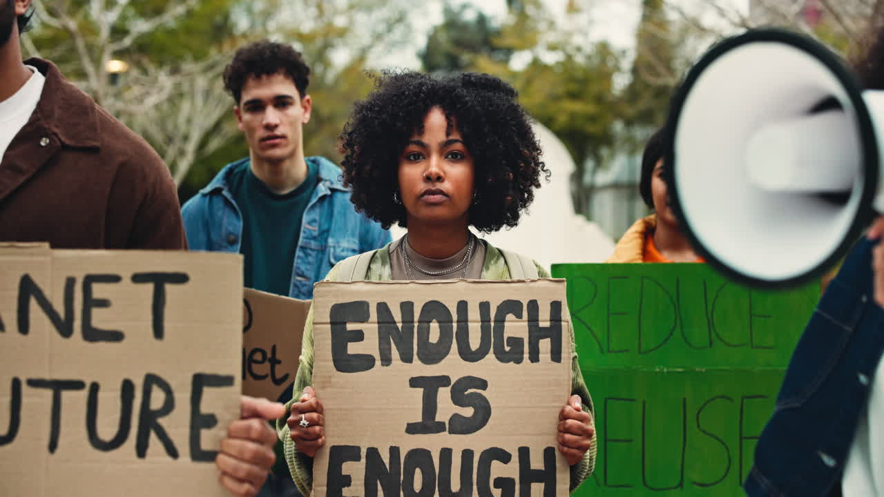 Determined Young Woman Holding 'Enough Is Enough' Sign at Protest