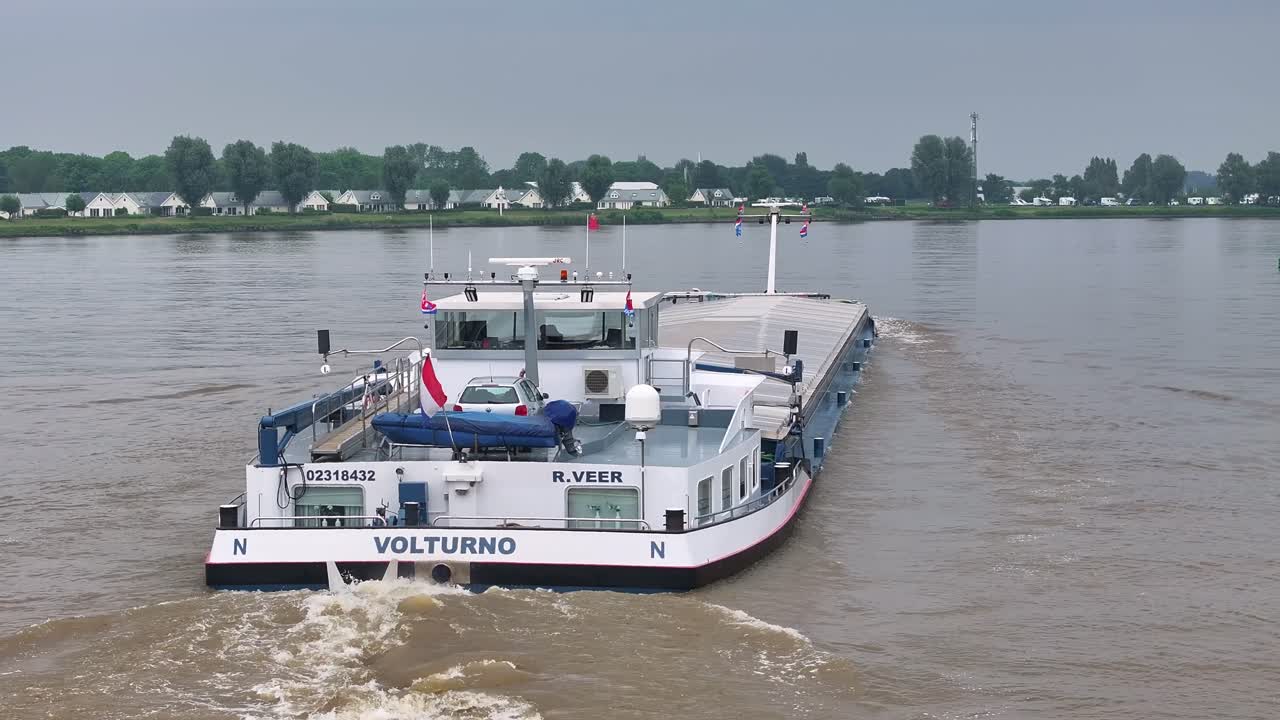 The cargo ship Volturno navigating an inland waterway on a cloudy day