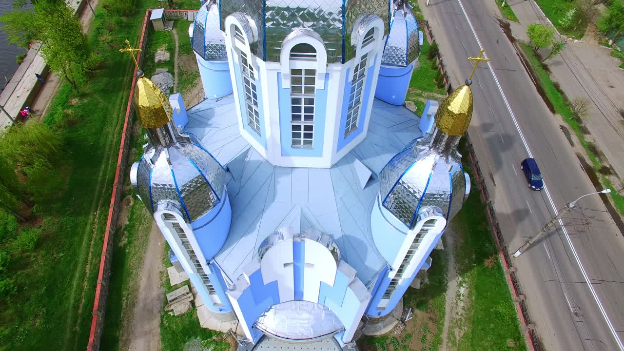 Beautiful orthodox cathedral on the picturesque riverbank. Scenery of Ukrainian city from top view.